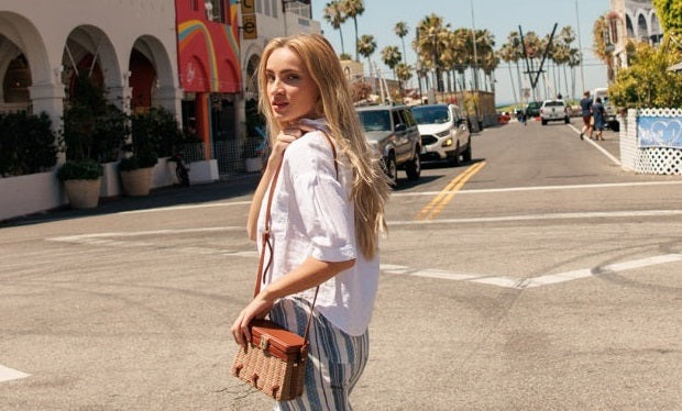 Woman in a coastal town wearing a coastal grandmother aesthetic outfit