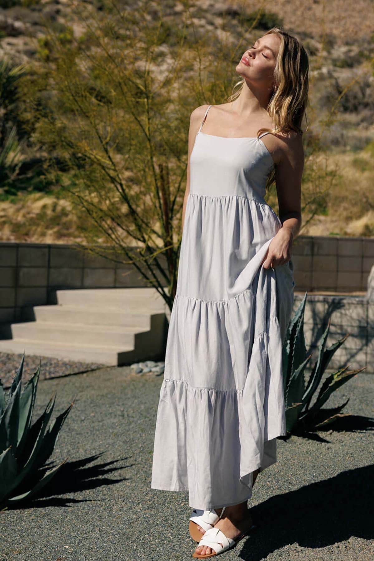 A woman wearing a light gray tiered maxi