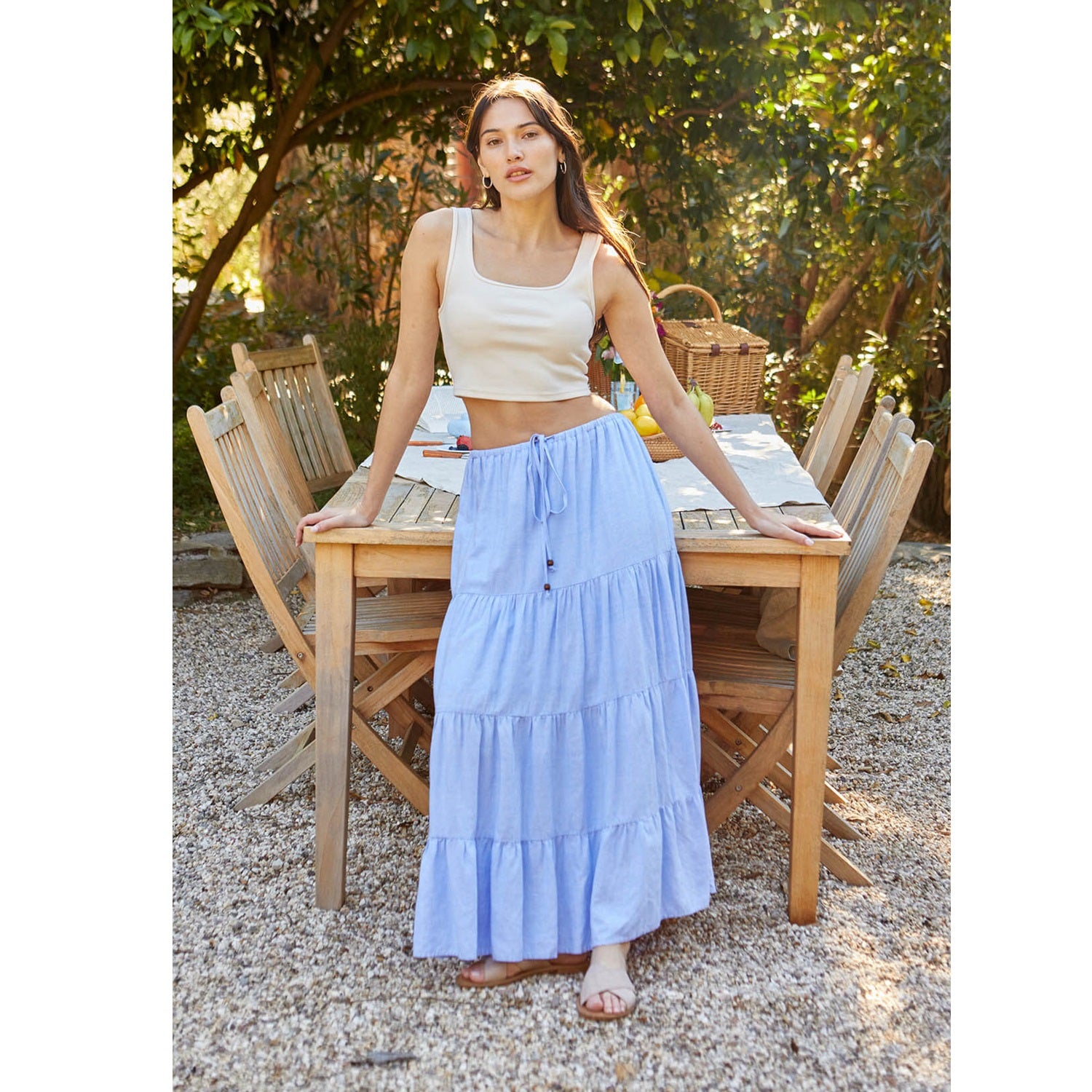 Woman wearing a blue linen skirt and a beige crop top