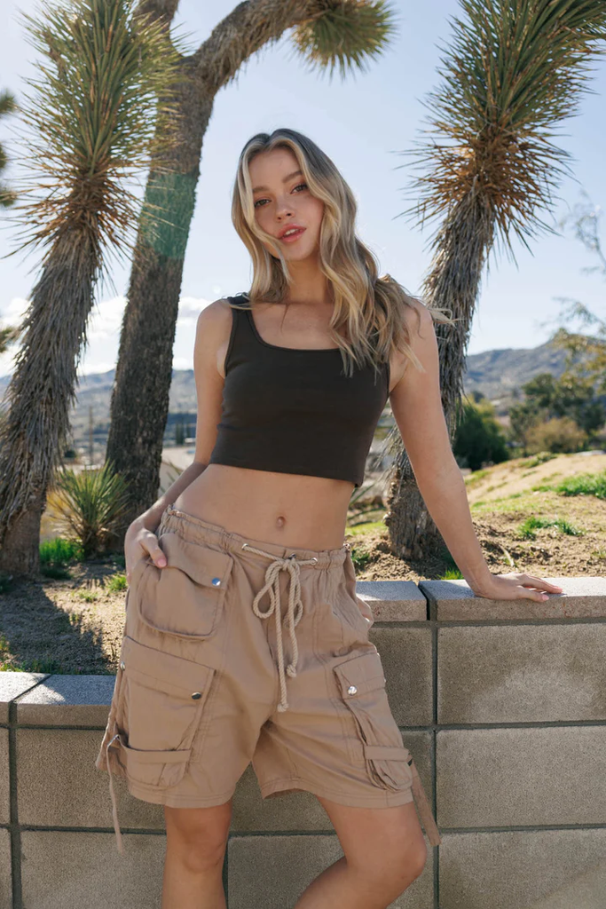 Woman wearing brown casual shorts with a black crop top
