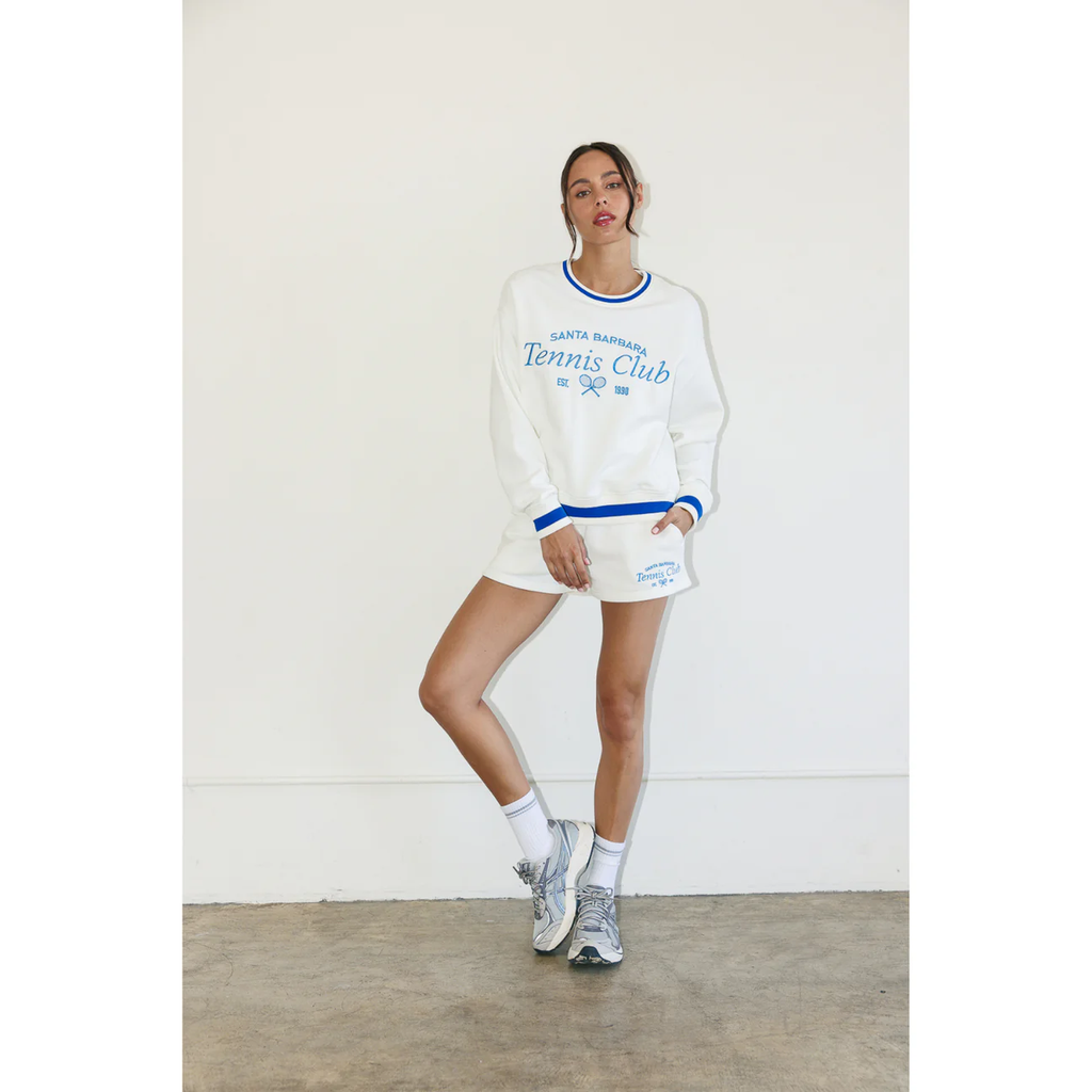 Woman in a cream sweatshirt and sweat shorts