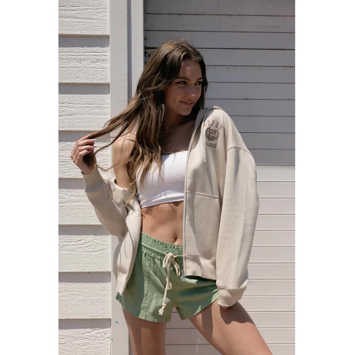 Woman in a cream sweatshirt and green shorts