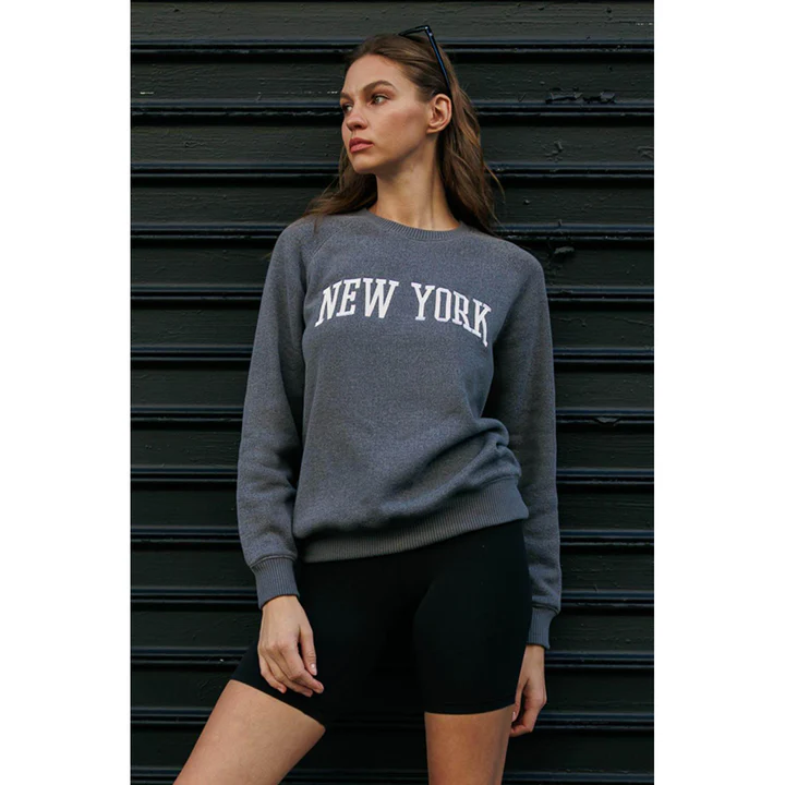 A woman in a grey New York sweatshirt