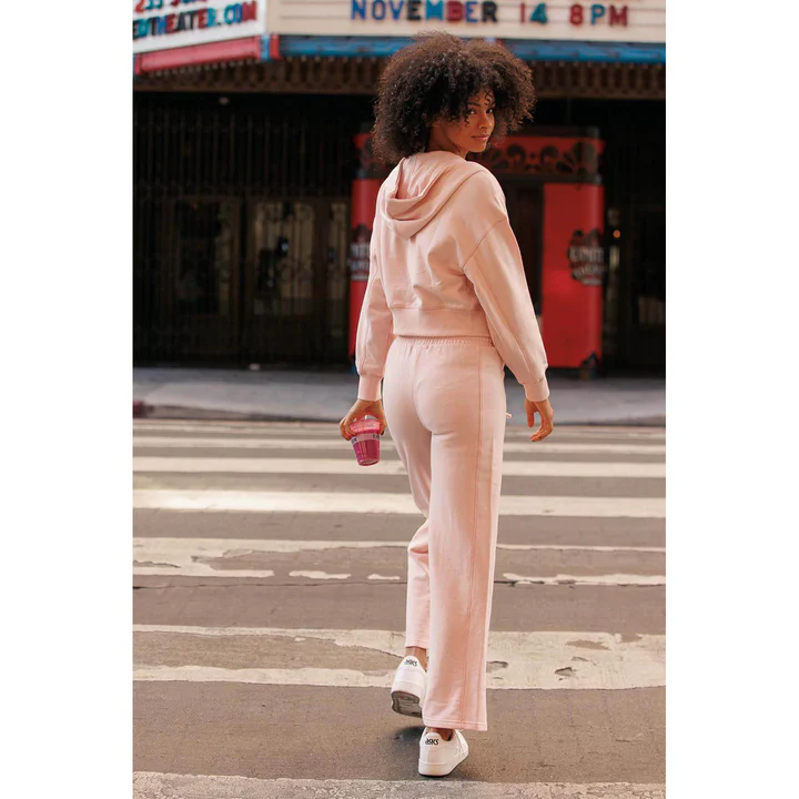 Woman in pink wide-leg sweats and a hoodie