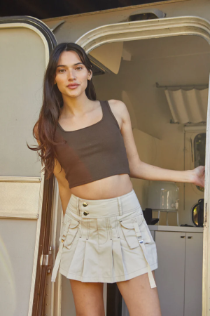 Woman wearing a pleated cargo mini shirt in khaki with brown crop top