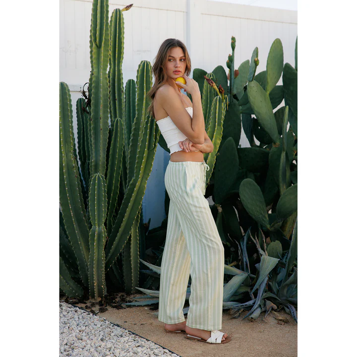 A woman wearing a printed linen pants and a tube top