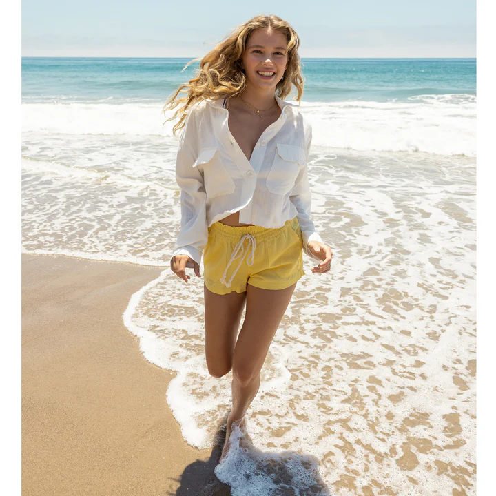 A woman at the beach wearing linen beach clothes