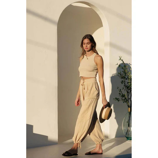 A model in light brown women’s gauze pants and a matching tank top