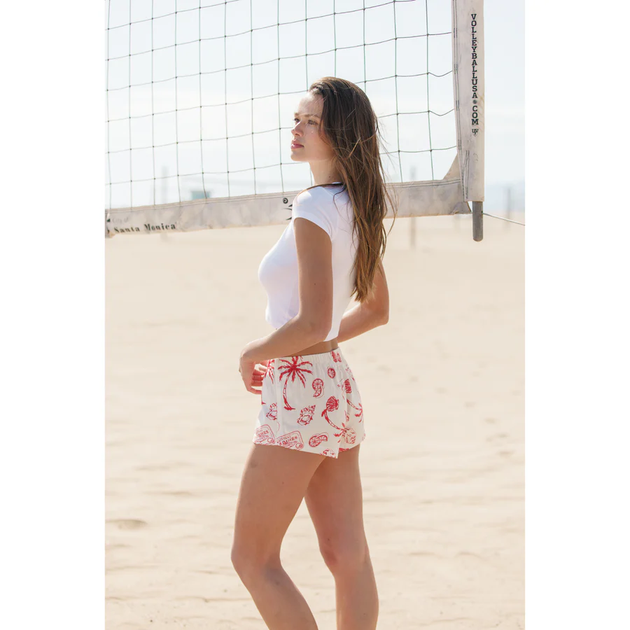 A model at the beach in a women’s red two-piece set